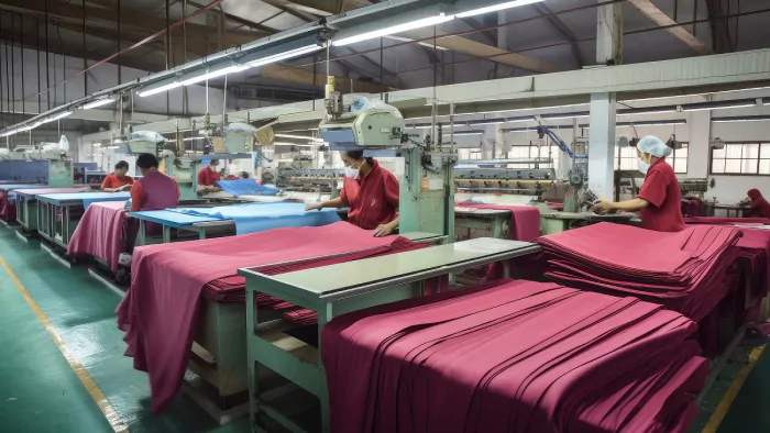 textile factory, with workers preparing bundles of fabric for shipping, created with generative ai
